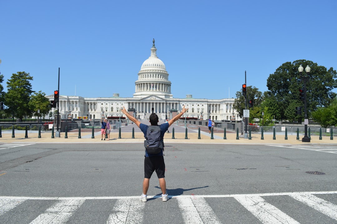 services-10 a-person-standing-in-a-crosswalk-in-front-of-a-white-building-qulmggtwrii